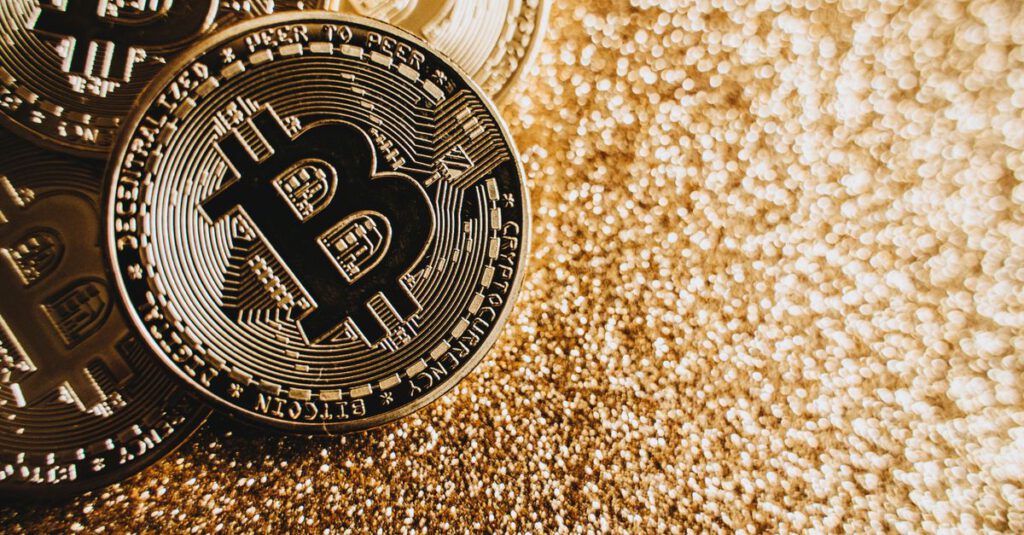 Symbolbild: Bitcoin-Münze vor digitalem Kursdiagramm